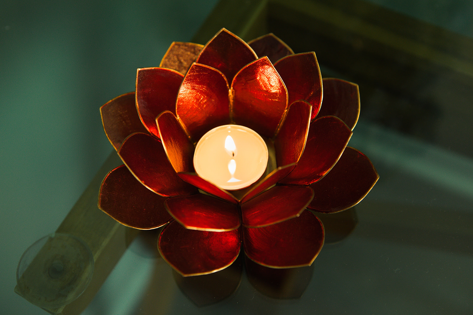 A lotus shaped candle holder glowing in soft light