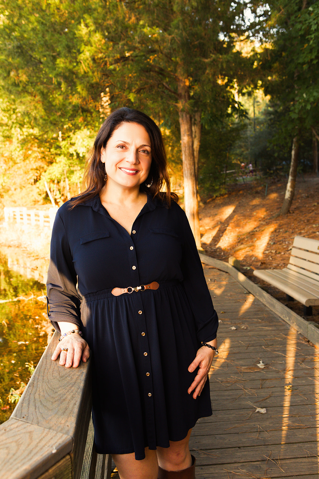 Nina standing on a wooded path in warm autumn light