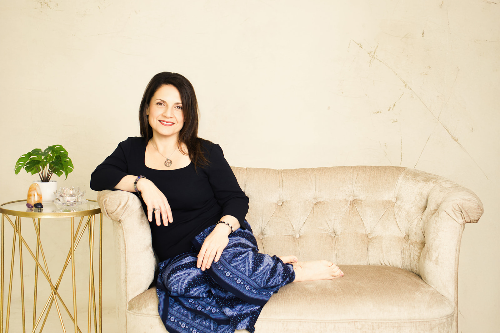 Nina sitting comfortably on a velvet settee, relaxed and at ease