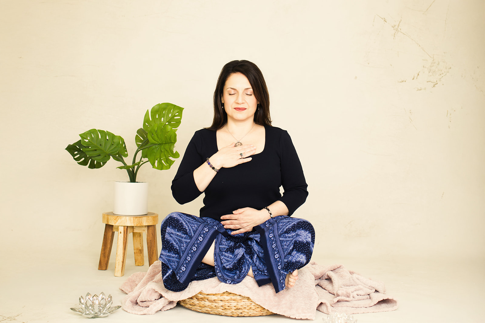 Nina seated in meditation with one hand resting on her heart