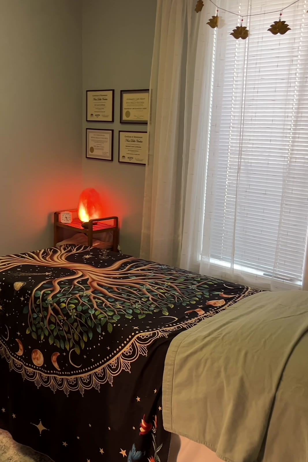 The treatment table in Nina's sanctuary, a salt lamp glowing beside the window
